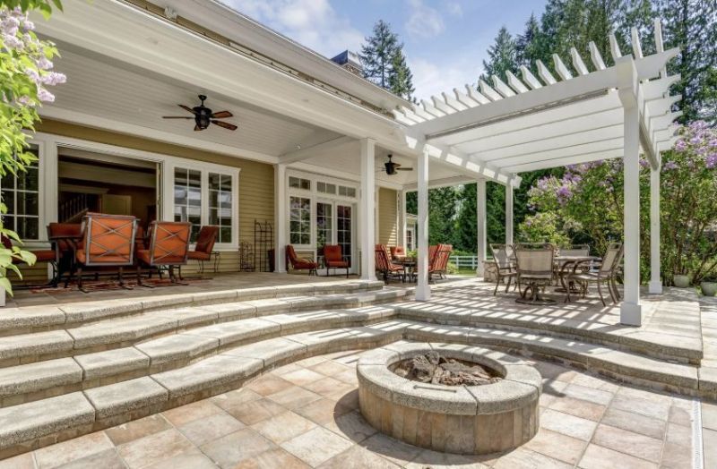 Backyard patio with pergola, stone steps, fire pit, and outdoor dining and lounge seating